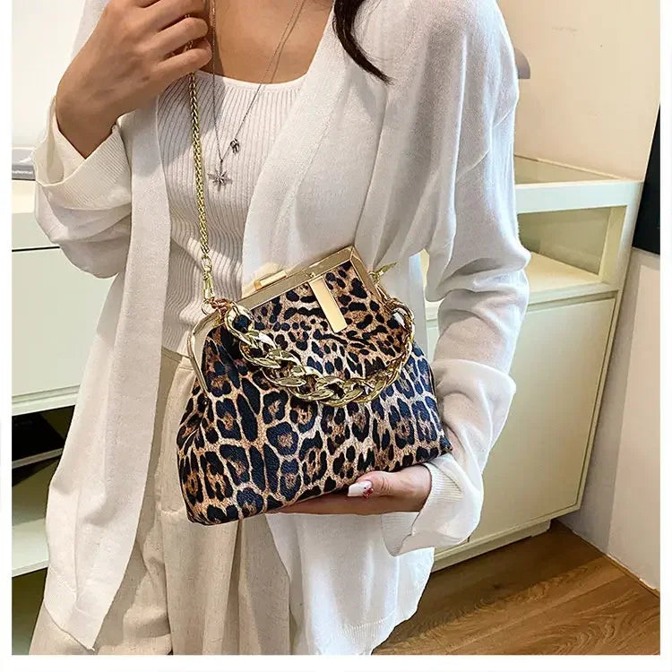Person holding a Carauana_UNIU_Leopard_Clutch indoors